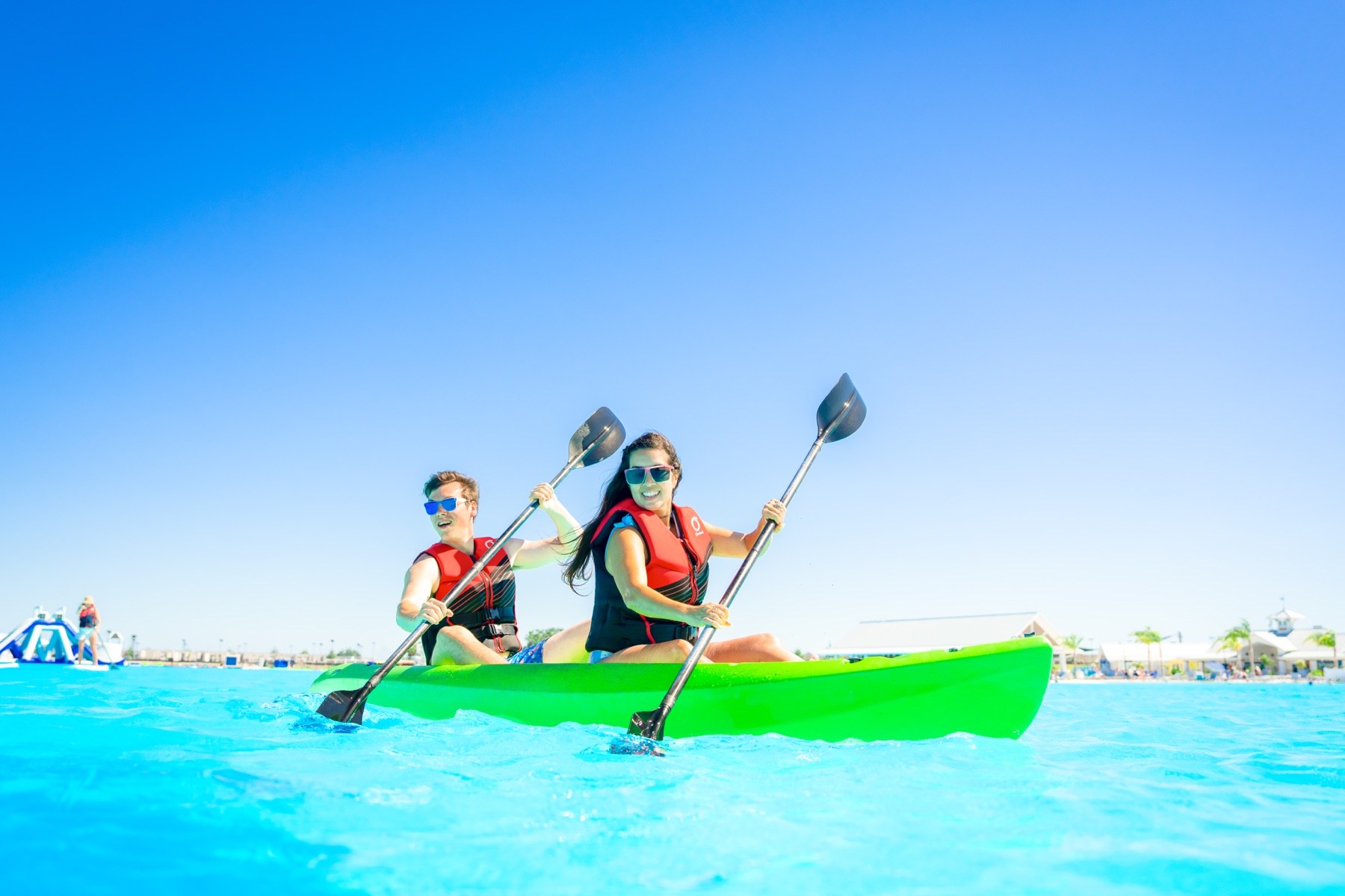Two people kayaking on the bright blue water at Mirada Lagoon in Pasco County, Florida